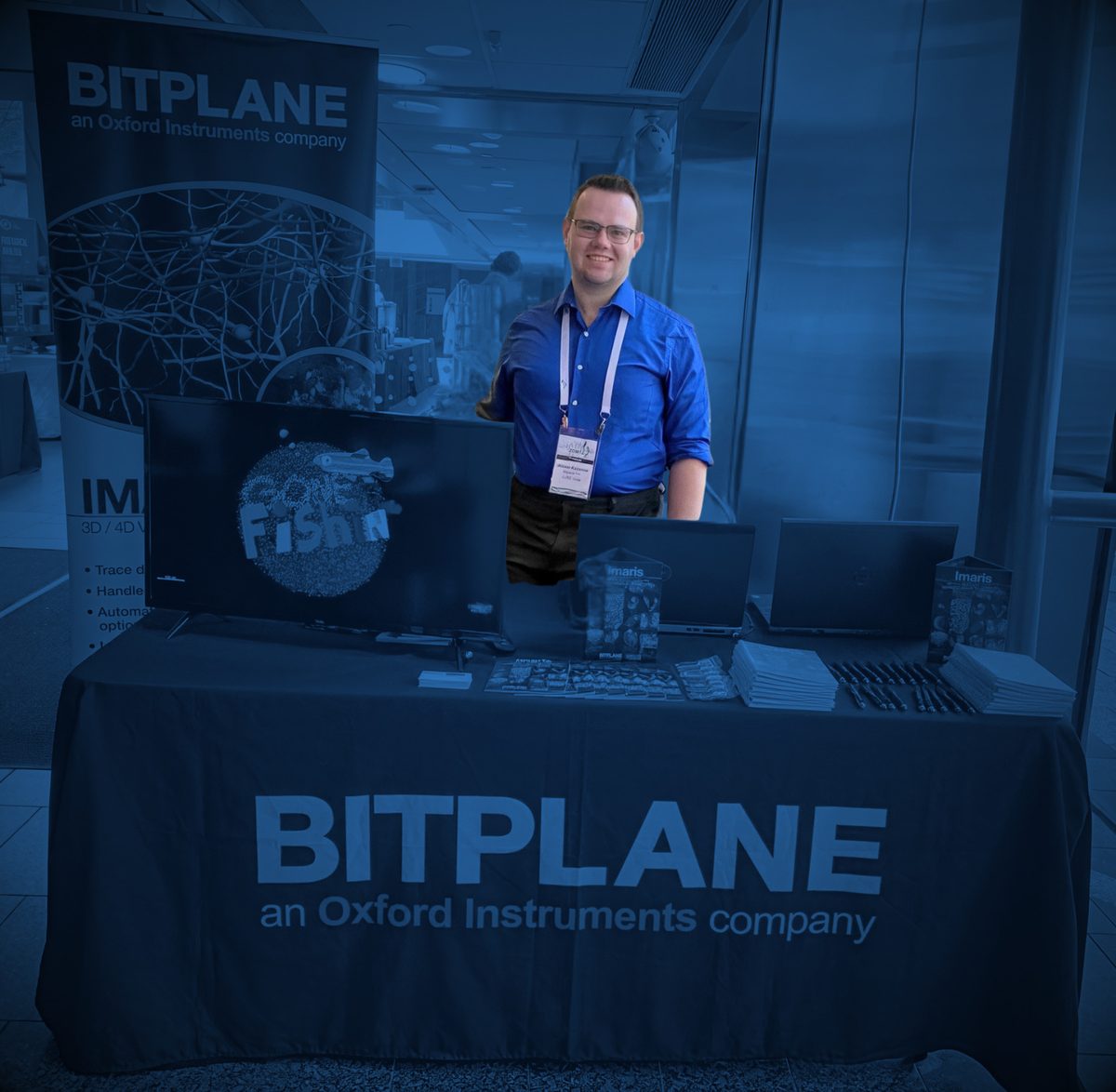 Alexei Kazarine at his first sales engineer event, staffing the Bitplane (an Oxford Instruments company) booth in company shirt and badge